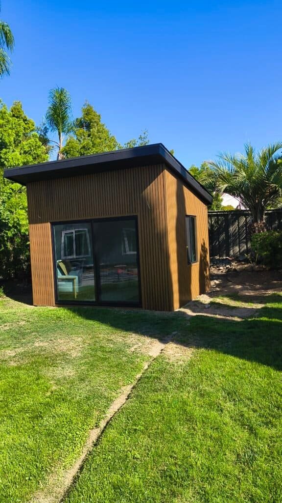 Contemporary tiny house with large glass doors and wooden exterior.