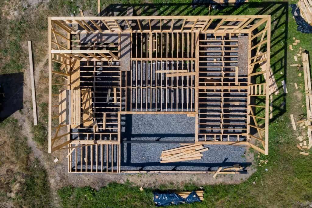 Aerial view of a house framing under construction with wooden beams and structure.