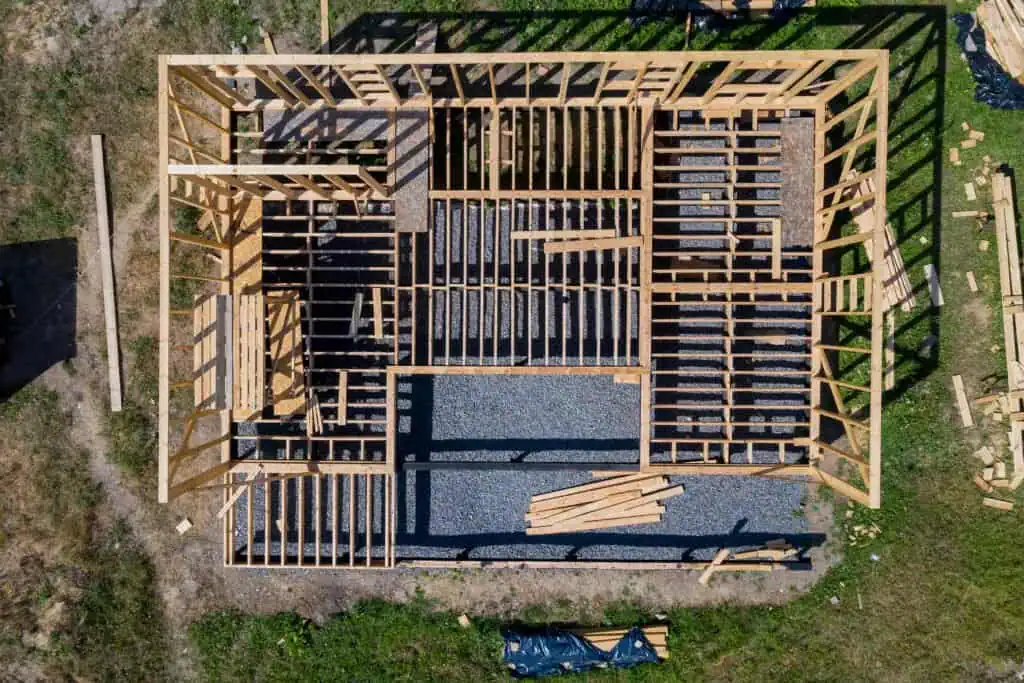 Aerial view of a house framing under construction with wooden beams and structure.