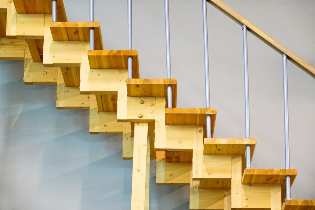 Contemporary wooden staircase with metal railing for interior design.